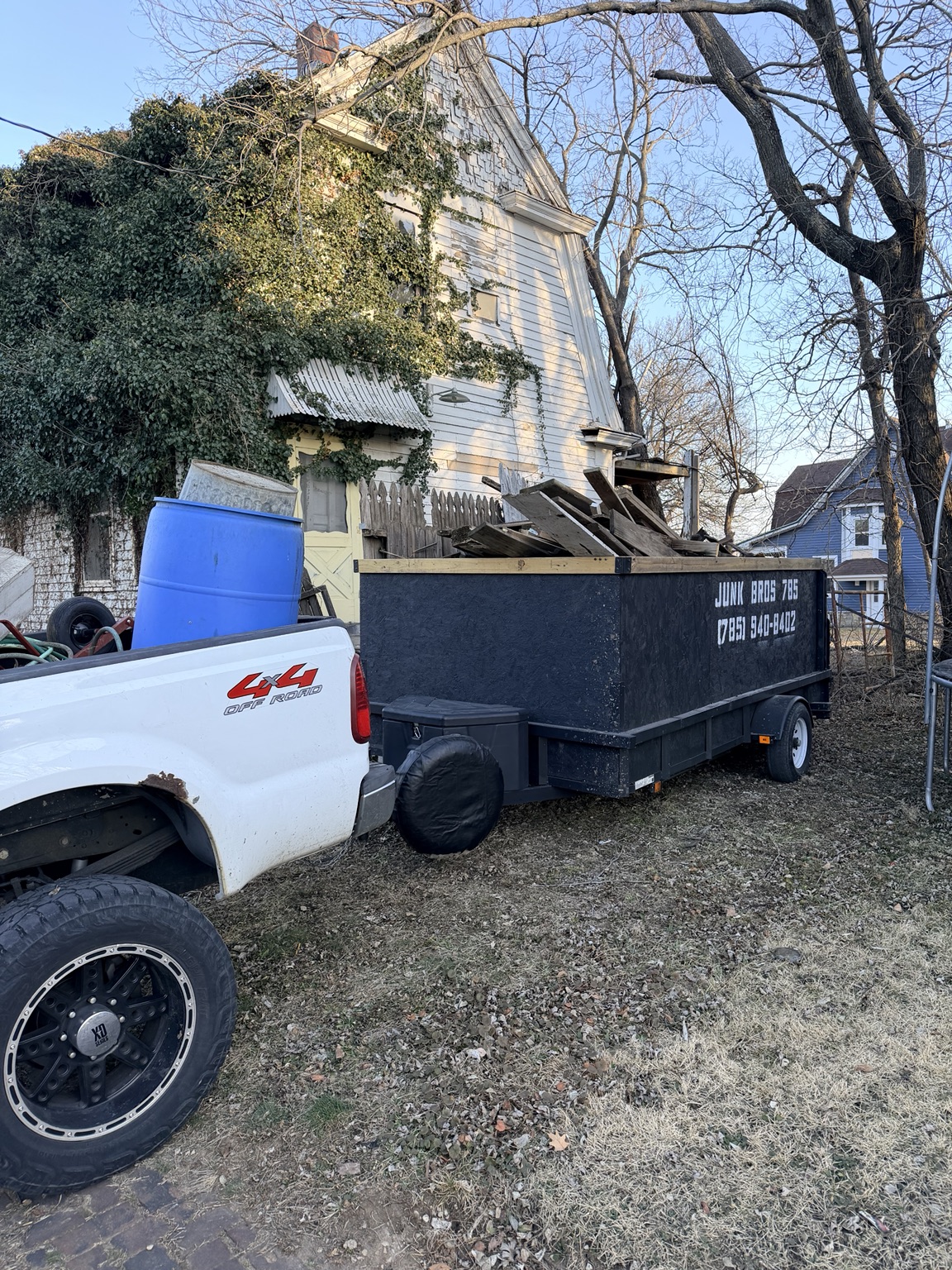 Junk Bros 785 trailer loaded with debris outside a house